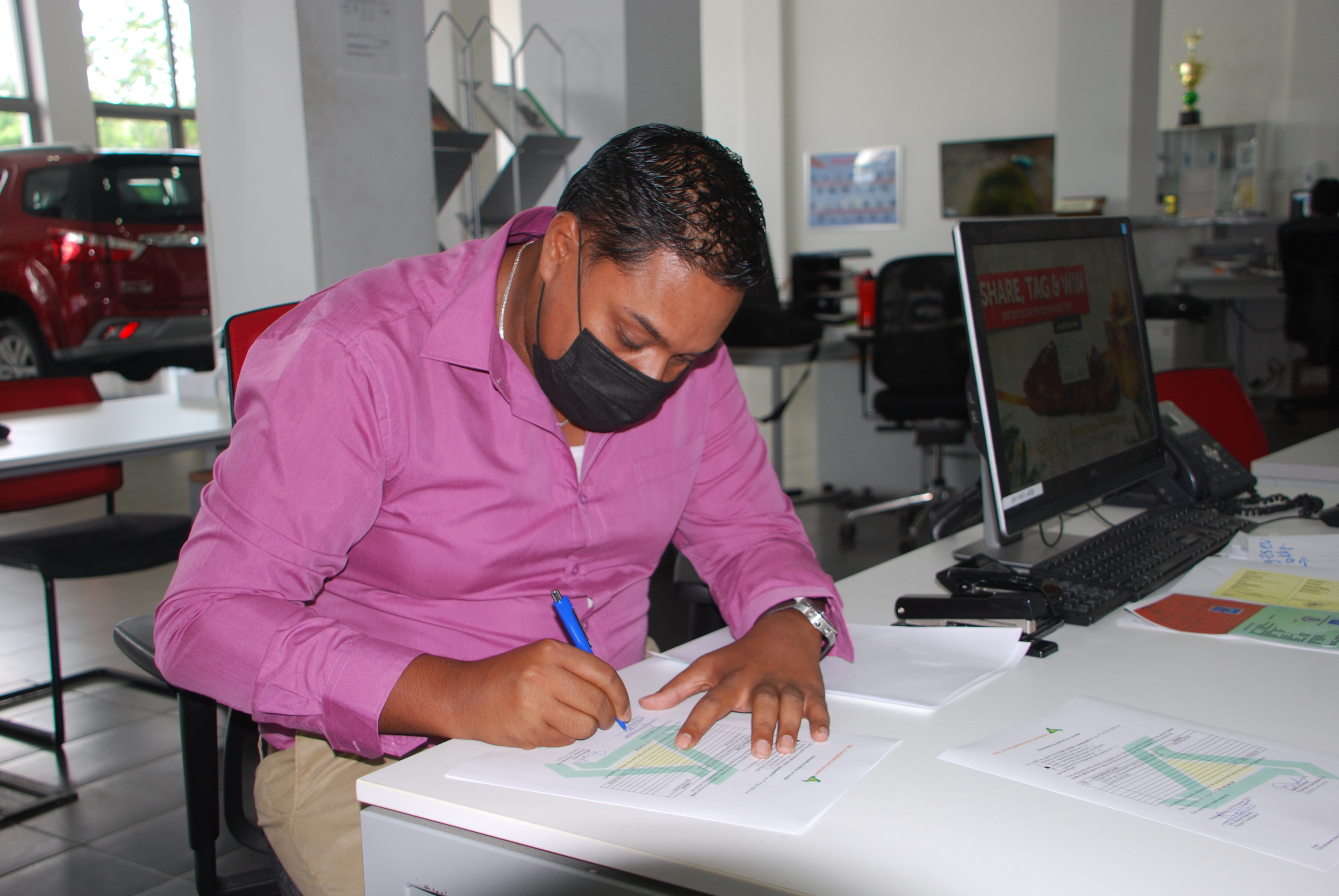 Foto: Shamir Bakridi zet namens de N.V. EBS, zijn handtekening onder de verkoopdocumenten.